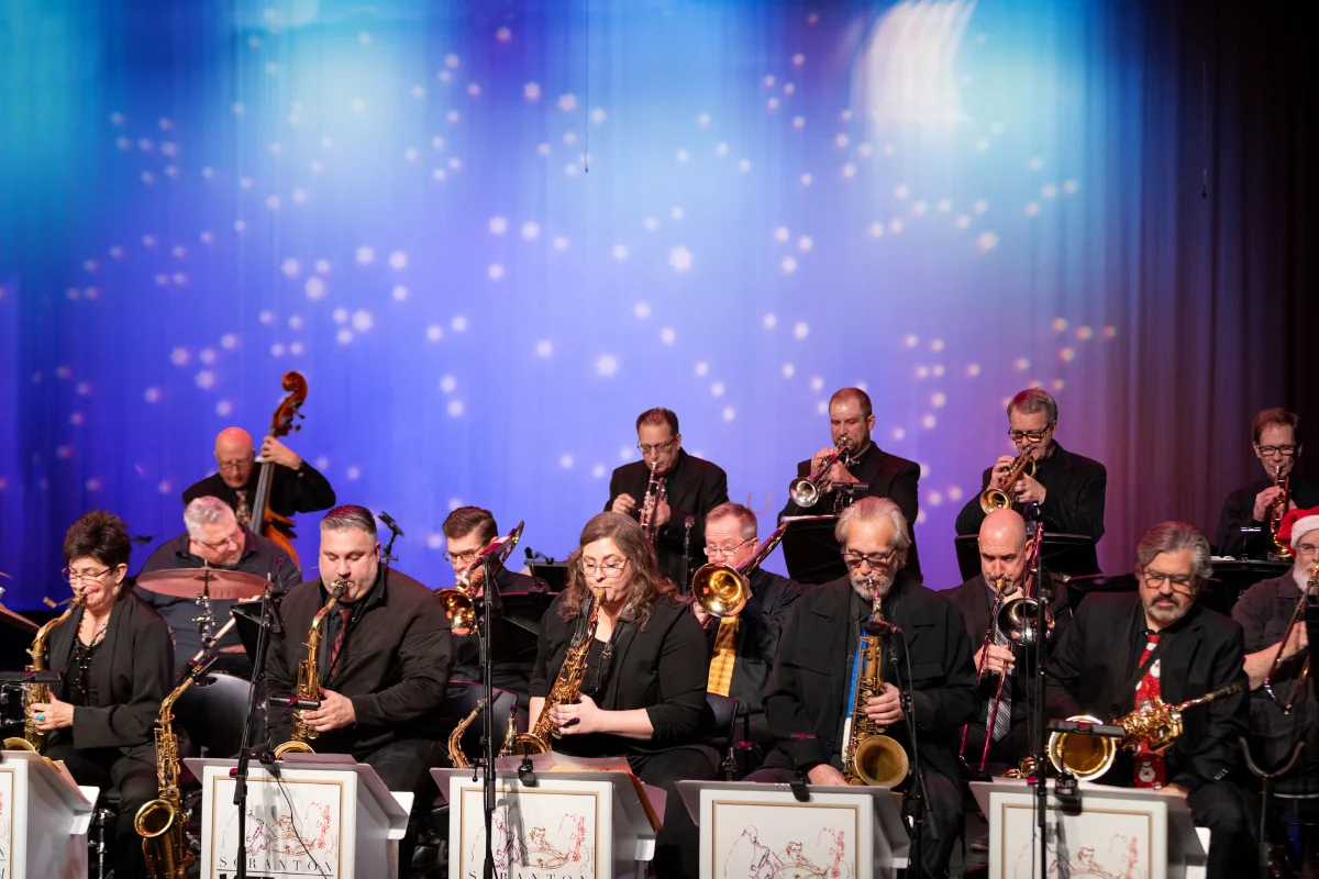 SJF Big Band performing on stage with horns and rhythm section